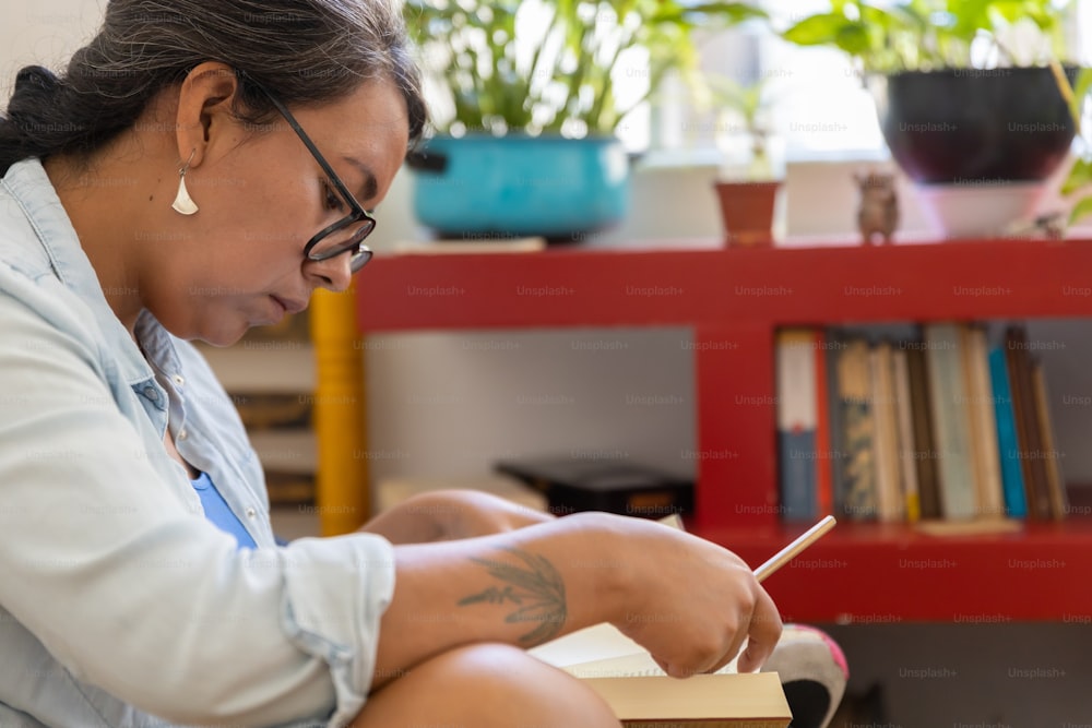 mexican tattooed millennial woman reading a book