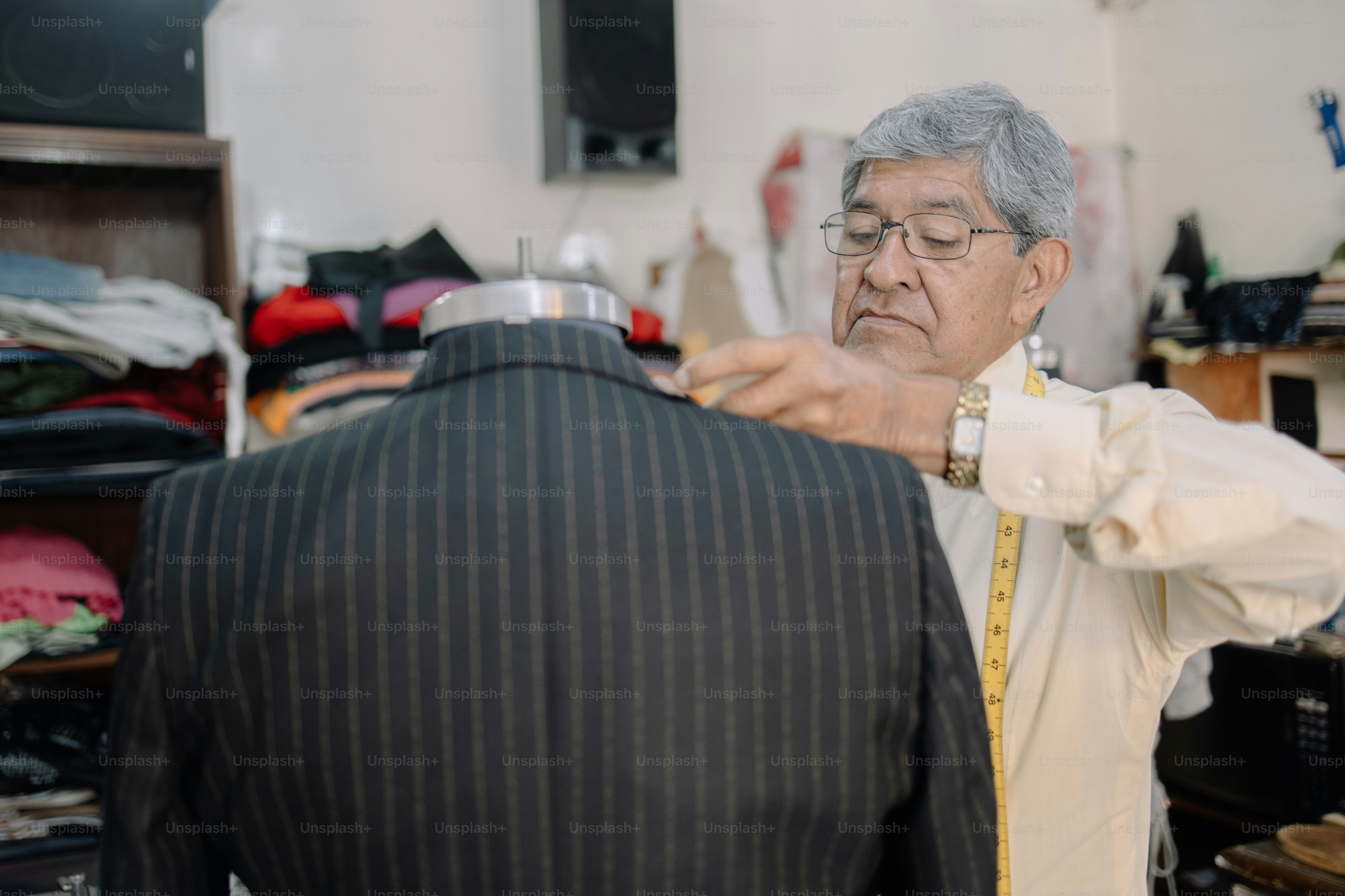 mature Mexican tailor working on local business