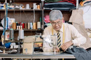 old mexican tailor working on workshop with sewing machine