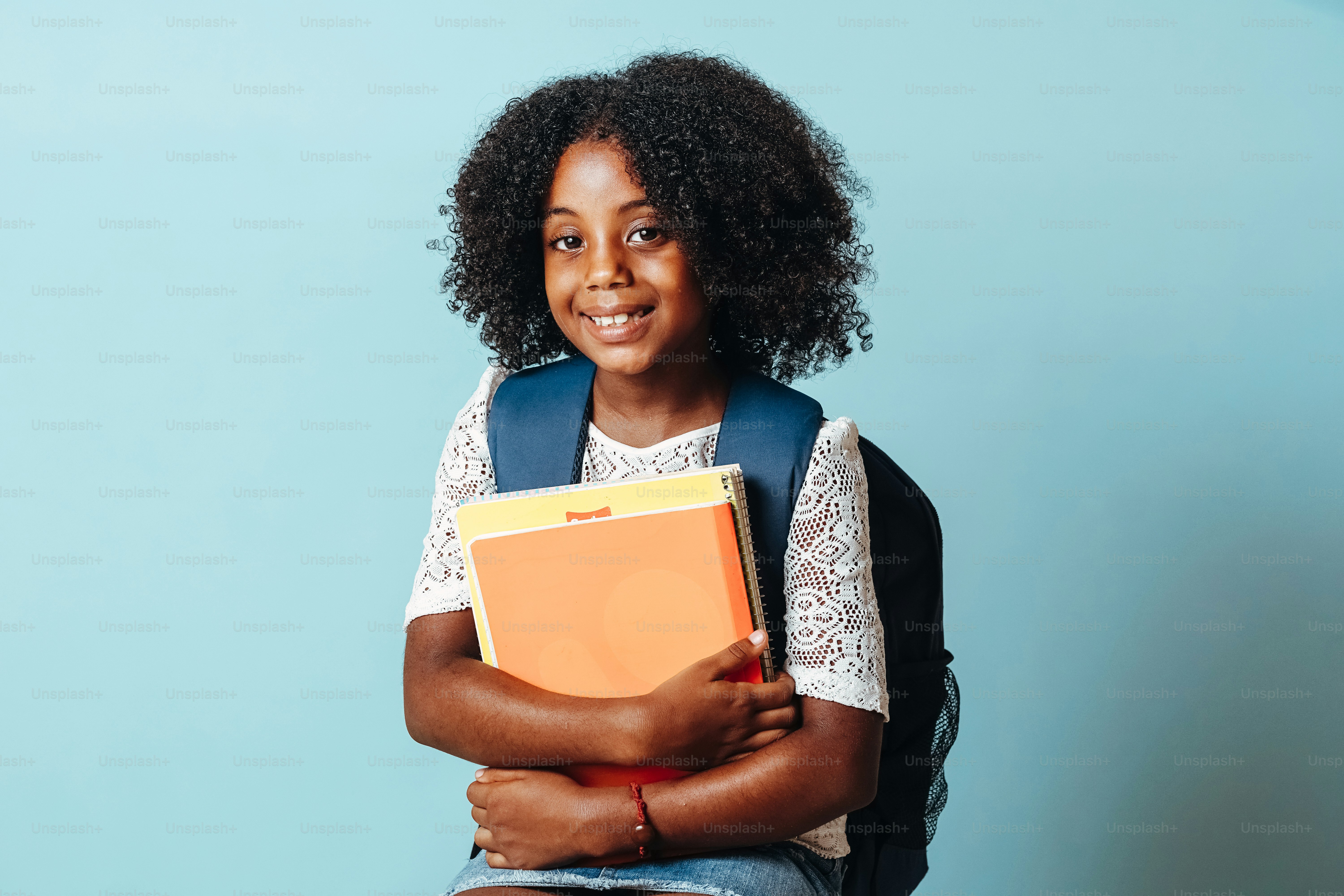 portrait of student girl with bag holding notebooks.