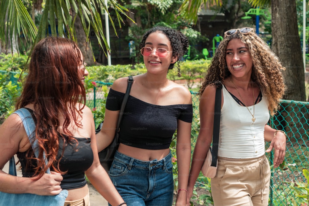 Three friends walking in the street in a city.