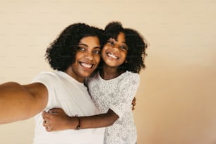 portrait of mother and daughter taking a selfie.