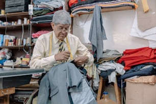Aged Mexican tailor sewing by hand on local business