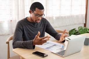 Afroamerikanischer Mann mit Online-Videoanruf Meeting auf Laptop zu Hause