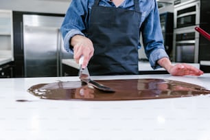 멕시코 라틴 아메리카의 주방에서 맛있는 과자 초콜릿을 준비하는 과정에서 검은 유니폼을 입은 라틴 여성 페이스트리 셰프의 손