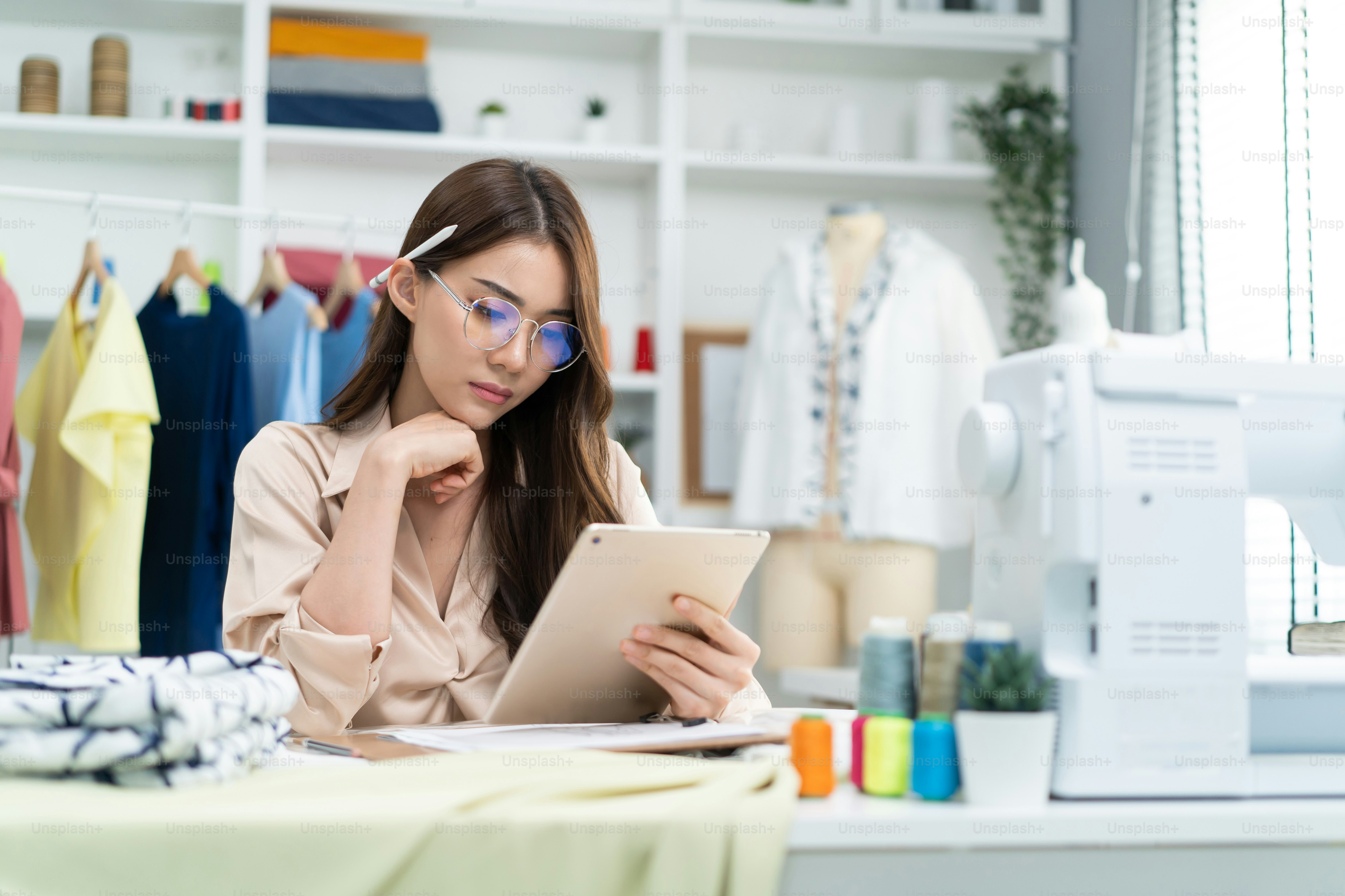 Mujer sastre asiática que trabaja para diseñar ropa nueva en un taller ...