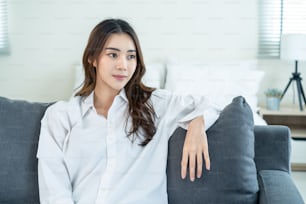 Portrait of Asian Beautiful girl in pajamas smile and look at camera. Attractive young woman feel fresh and happy to wake up early from bed in bedroom in the morning at home. healthy lifestyle concept