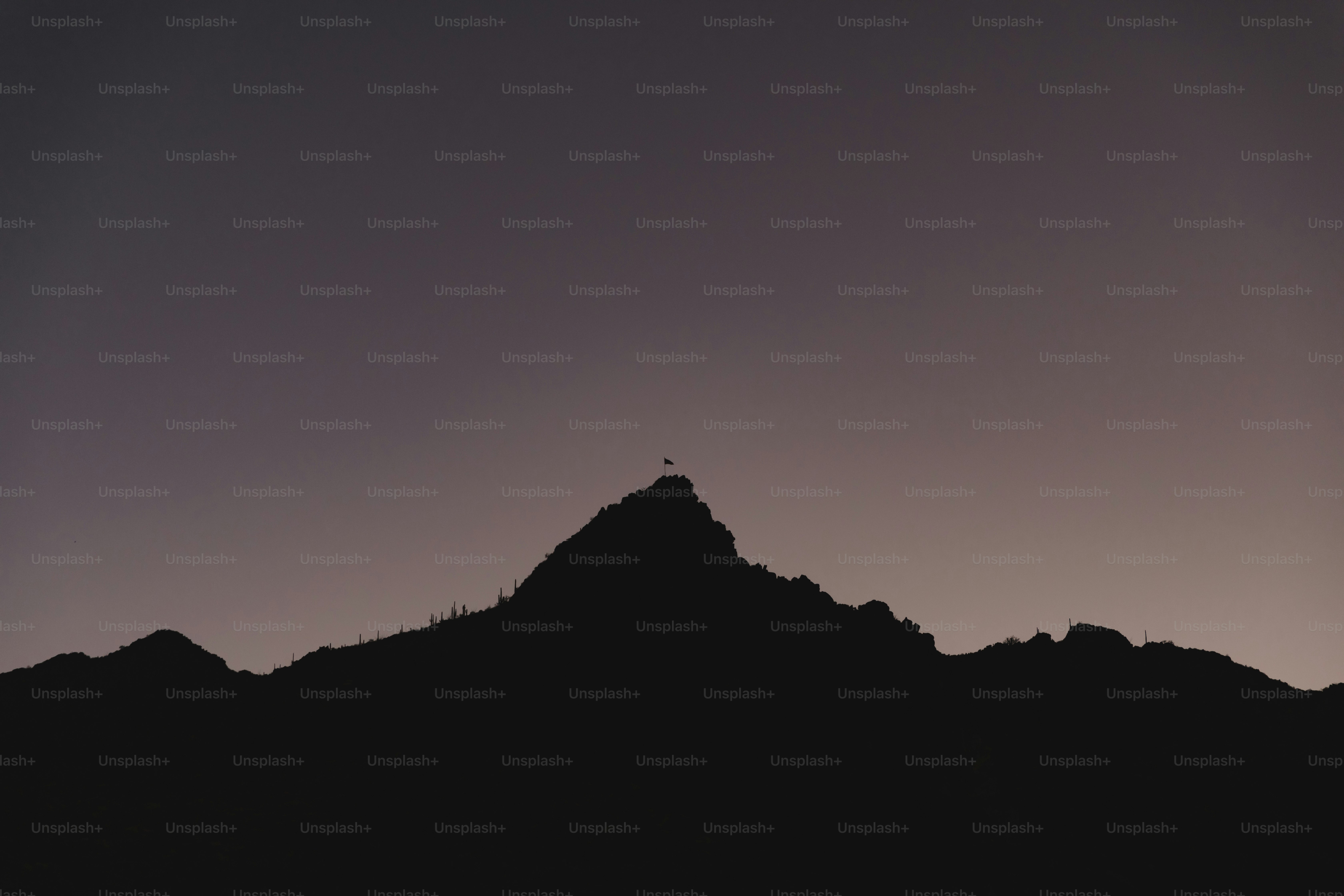 siluet seseorang yang berdiri di atas gunung