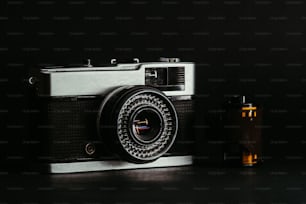 an old fashioned camera next to an empty bottle