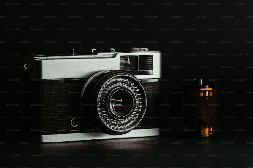 an old fashioned camera next to an empty bottle