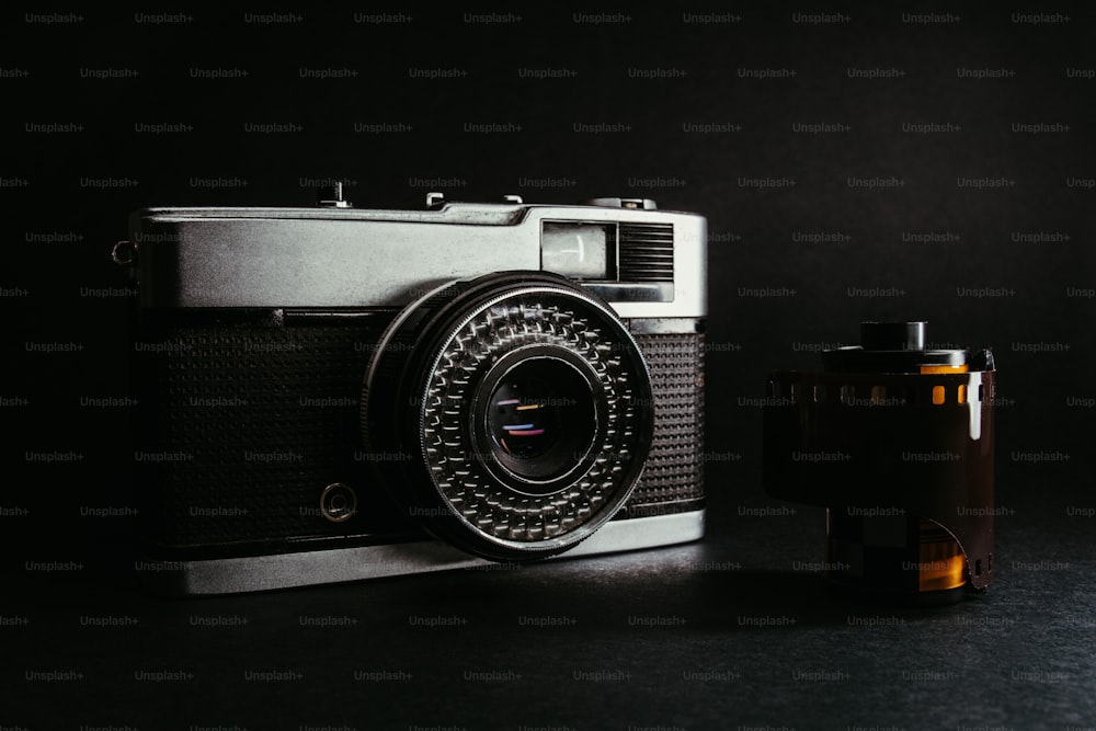 a camera sitting next to a bottle on a table