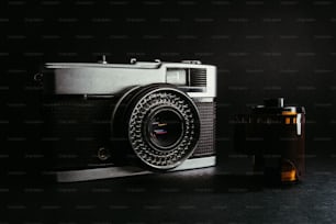 a camera sitting next to a bottle on a table