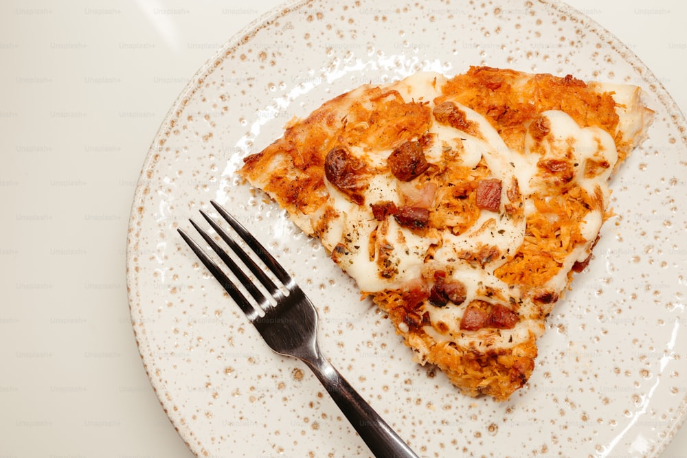 une tranche de pizza sur une assiette avec une fourchette