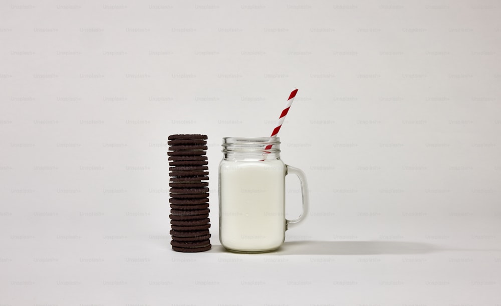 um copo de leite ao lado de uma pilha de biscoitos