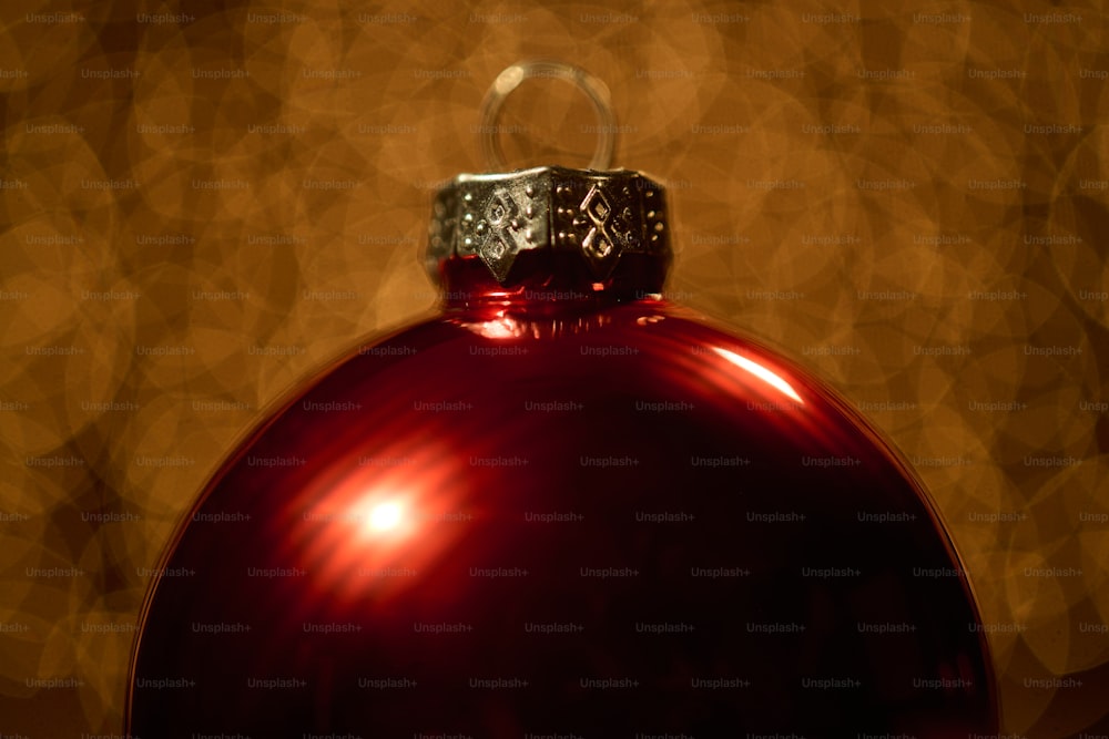 um ornamento vermelho brilhante com um anel de diamante sobre ele