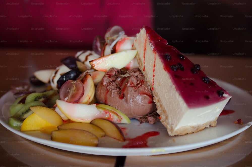 a white plate topped with a piece of cake next to fruit