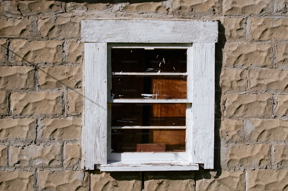 a window with a wooden frame on a brick wall