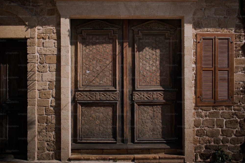 a large wooden door sitting next to a stone building