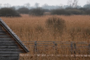 a barn in a field with a fence in front of it