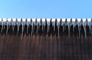 Des glaçons sont suspendus au toit d’un bâtiment