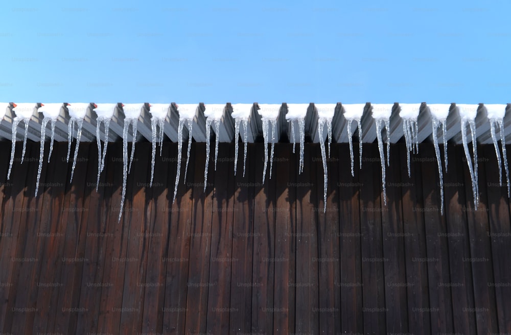 icicles are hanging from the roof of a building