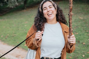 Una mujer sosteniendo un palo y sonriendo a la cámara