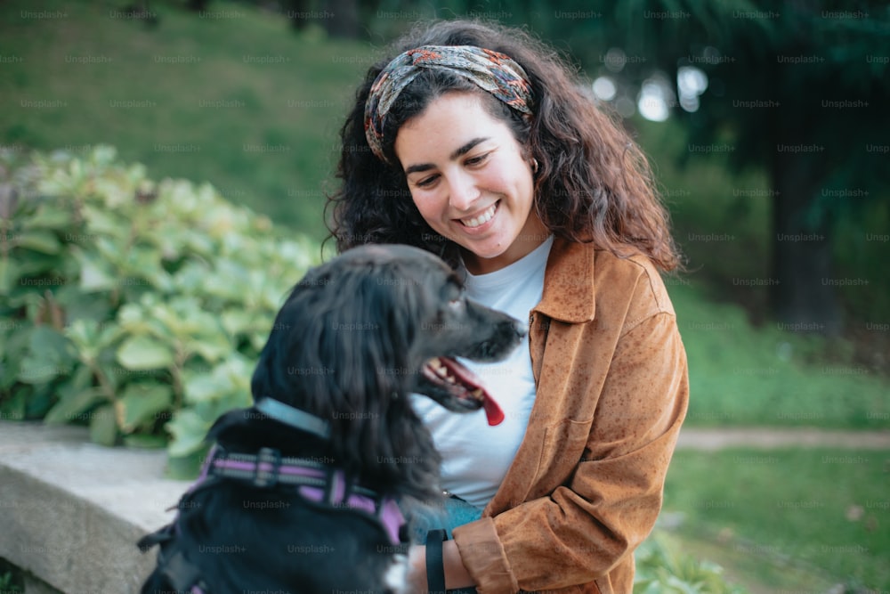 a woman sitting on a bench petting a dog