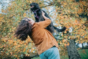 Un hombre sosteniendo a un perro en el aire