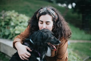 a woman hugging a black and white dog
