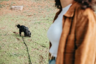 Una mujer de pie junto a un perro en un exuberante campo verde