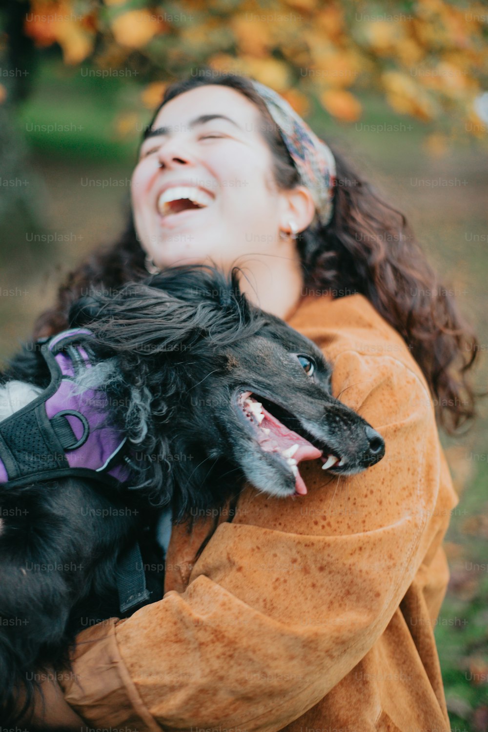Una mujer sosteniendo un perro negro en sus brazos