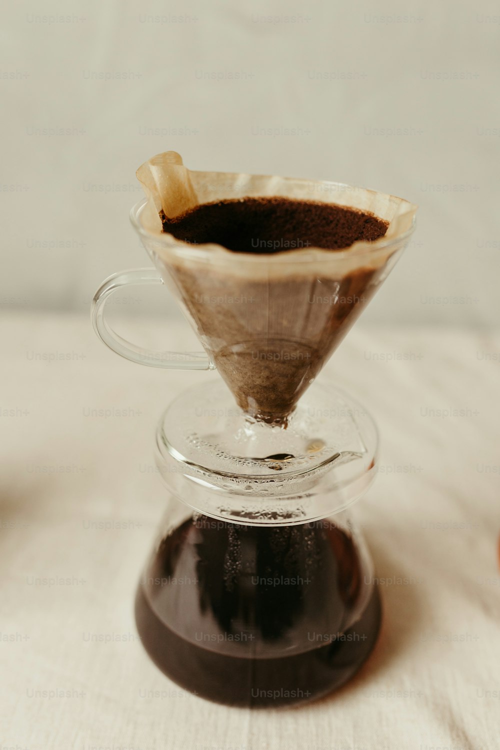 a pour - over coffee maker filled with coffee sits on a table