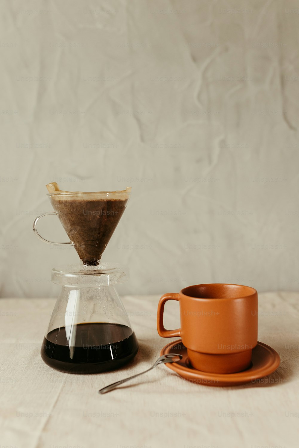 eine Tasse Kaffee neben einer Kaffeekanne