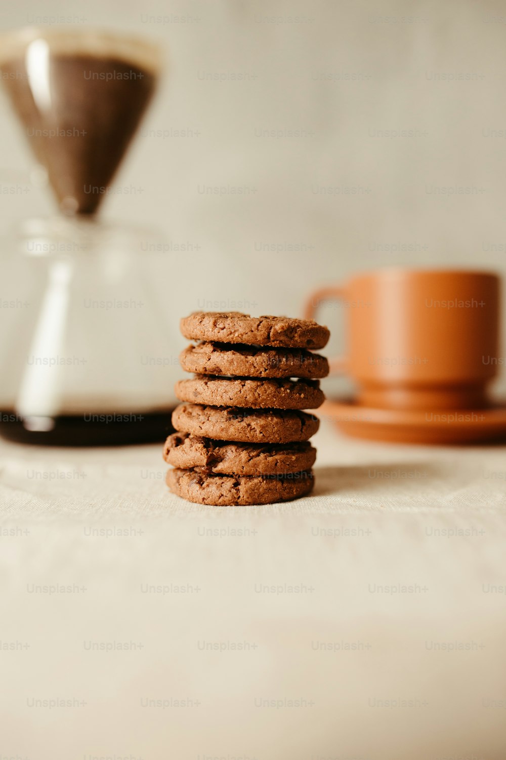 uma pilha de biscoitos sentada ao lado de uma xícara de café