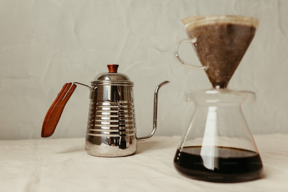 eine Kaffeekanne neben einer Glaskaraffe mit Holzgriff