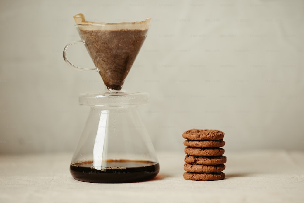 ein Stapel Kekse neben einem Glas Kaffee