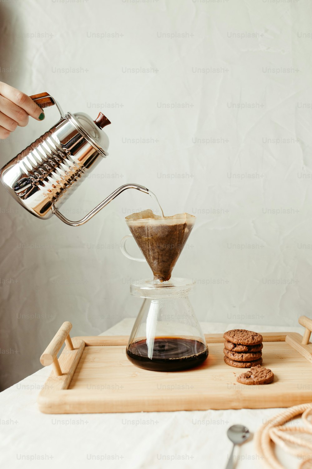 a person pours coffee into a glass pitcher