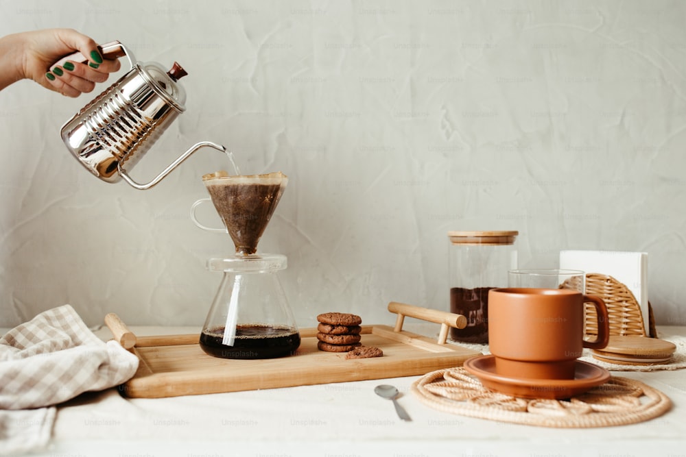 une personne verse du café dans une tasse en verre