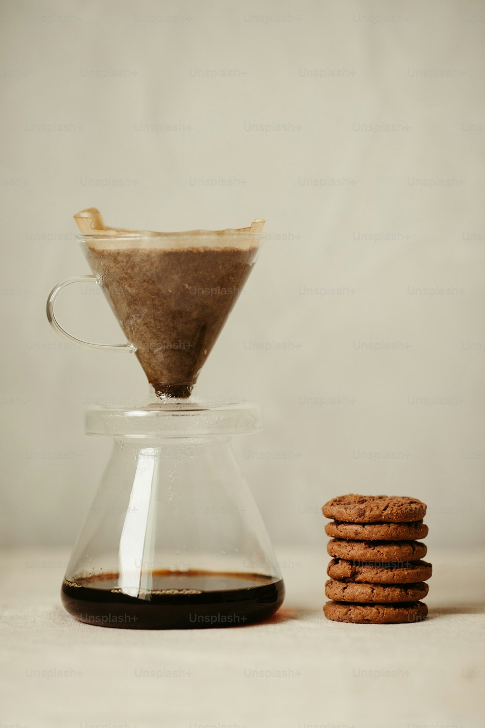 a stack of cookies sitting next to a coffee pot