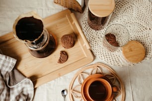 a wooden tray topped with cookies next to a cup of coffee