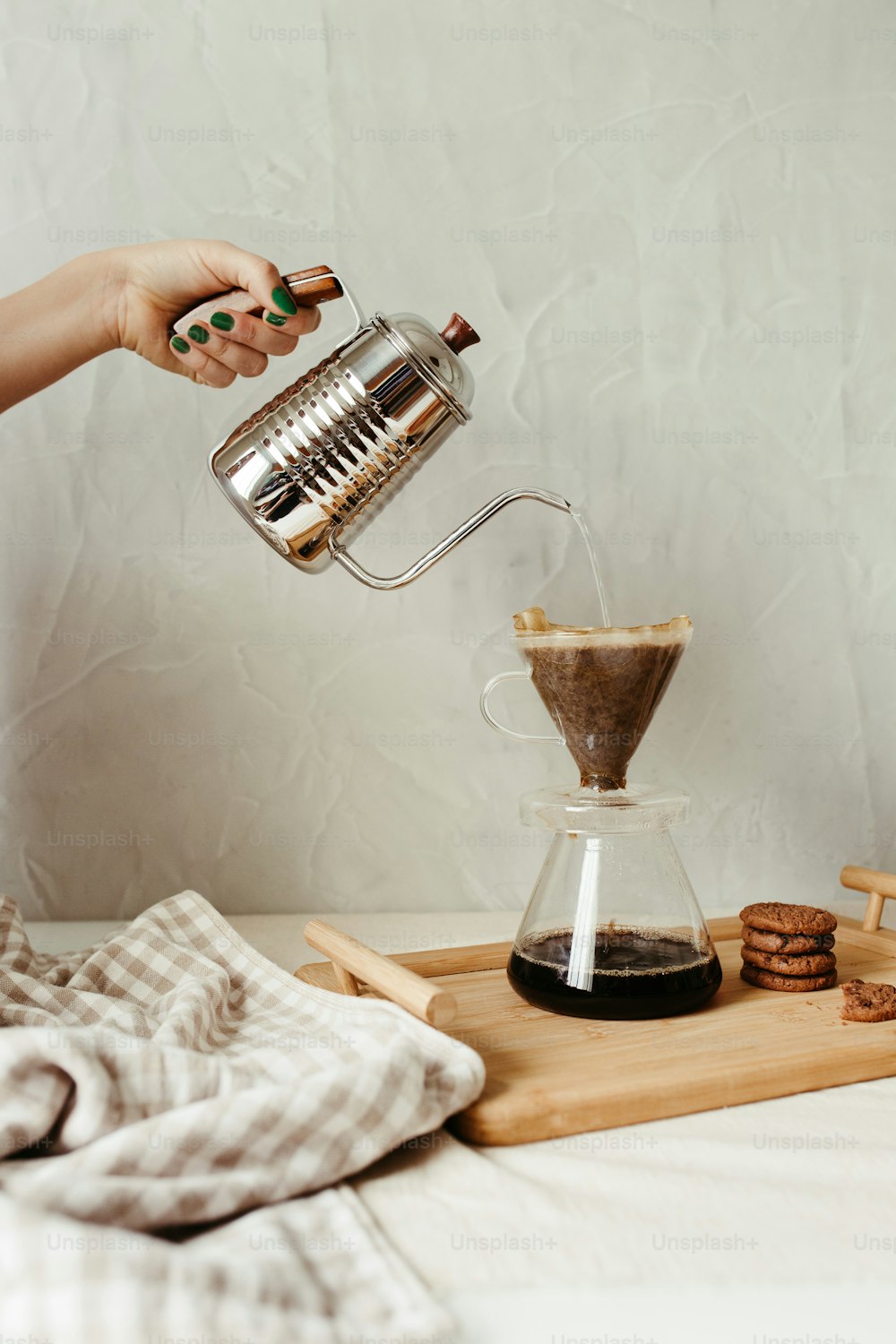 a person pours coffee into a glass cup