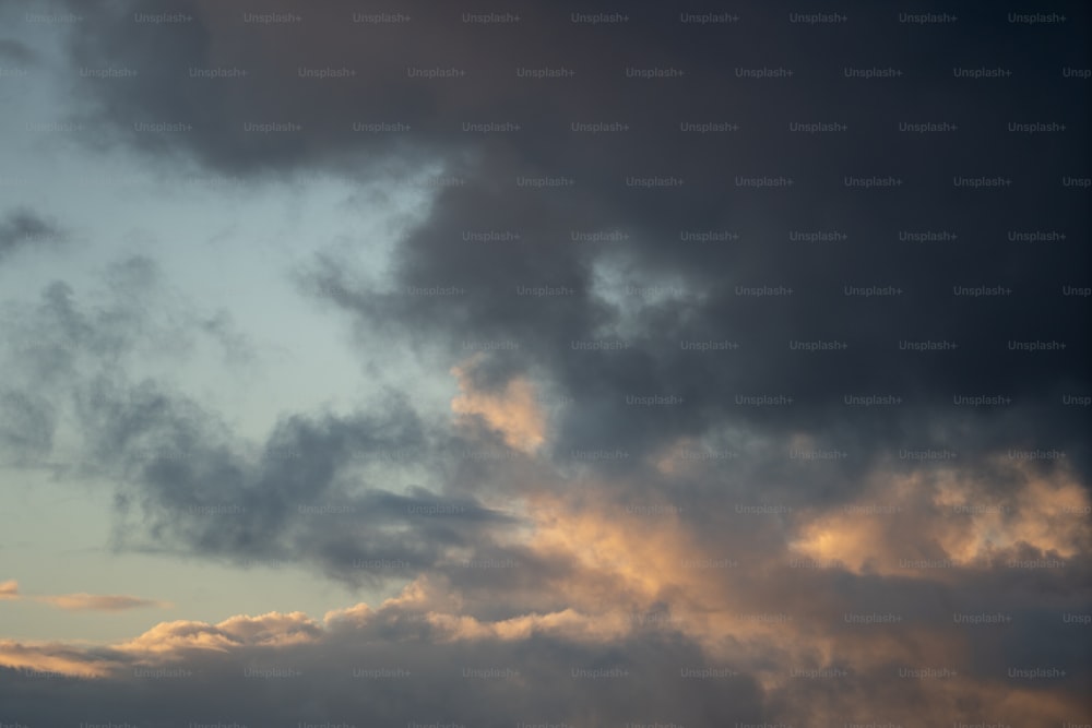Un avion volant dans un ciel nuageux au coucher du soleil