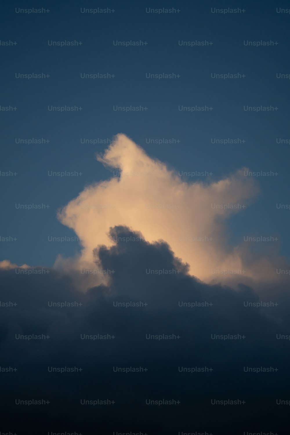 a plane flying through a cloudy blue sky