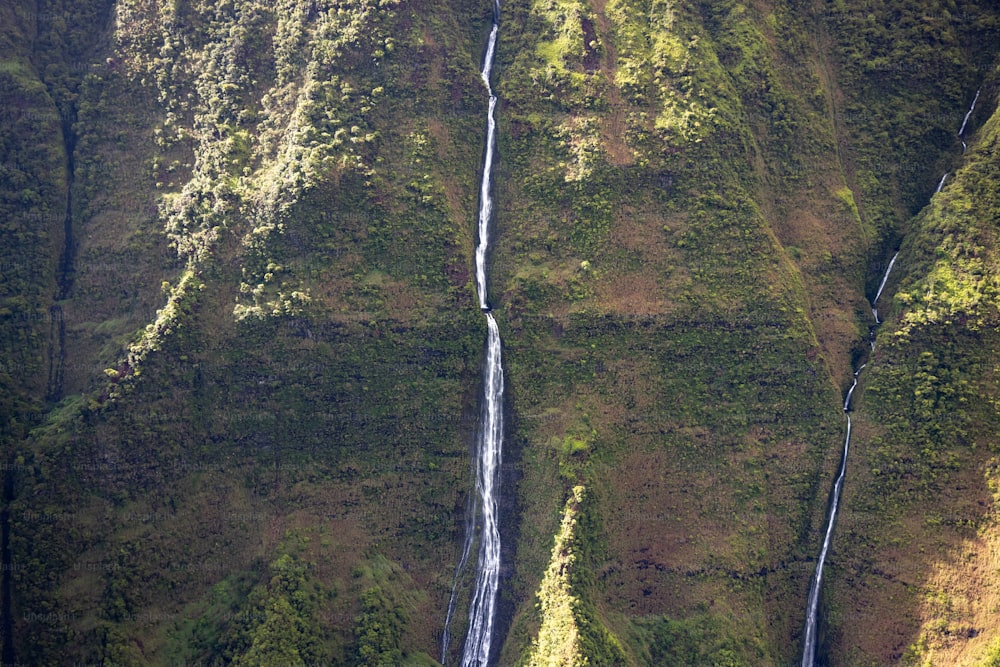 an aerial view of a waterfall in the mountains