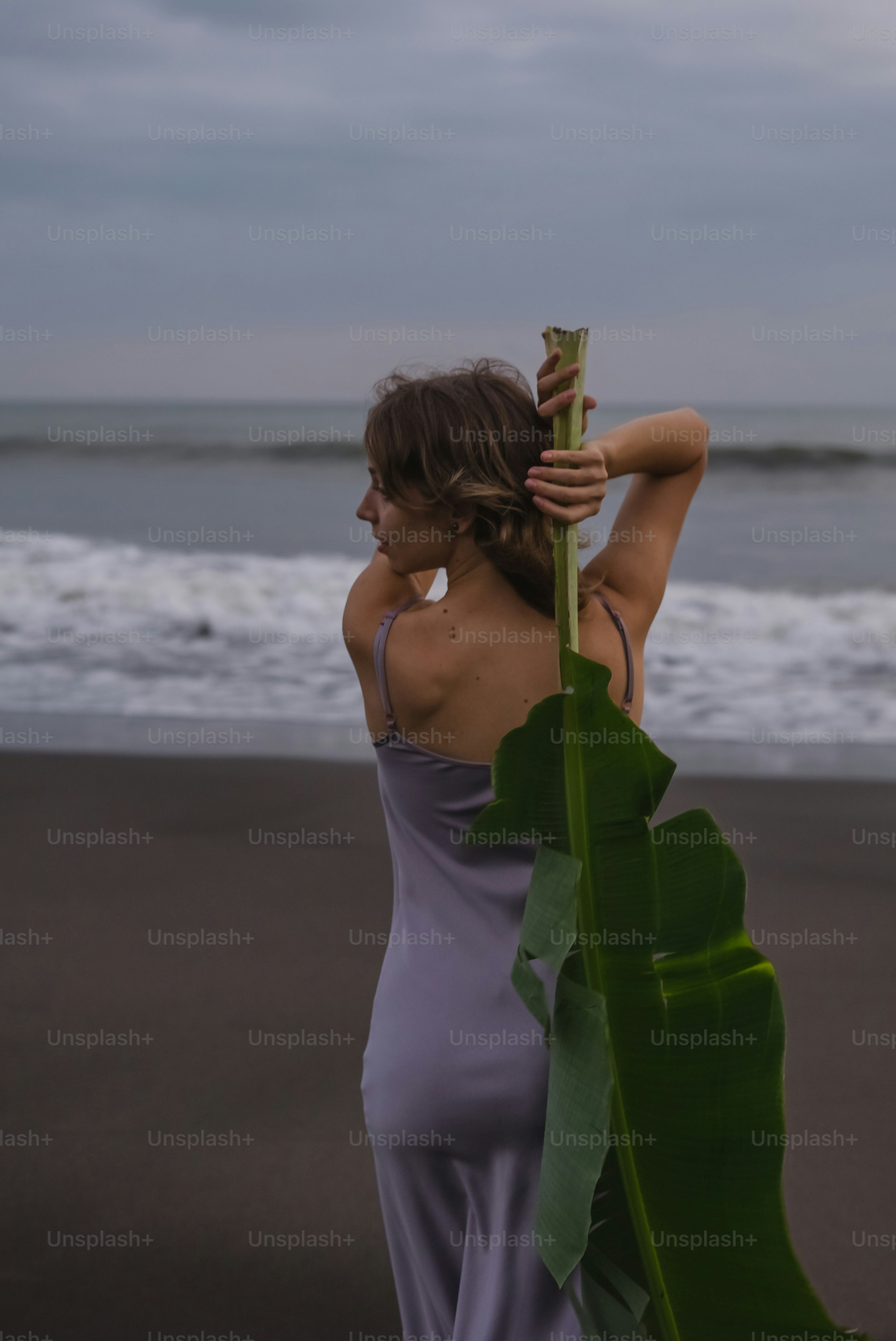 Una donna in piedi su una spiaggia vicino all'oceano