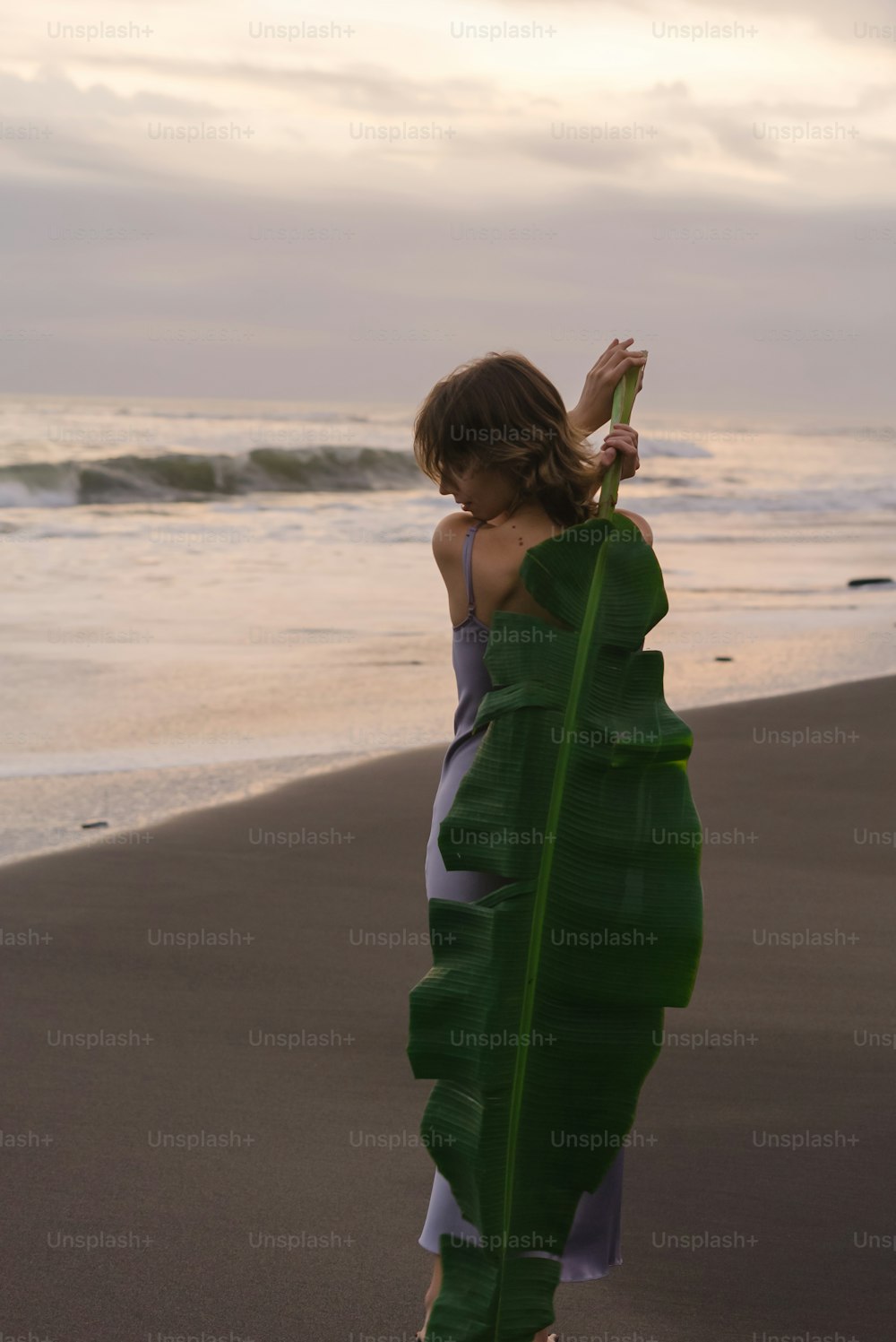 a woman standing on top of a beach next to the ocean