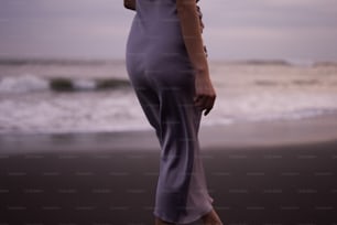 a woman standing on a beach next to the ocean