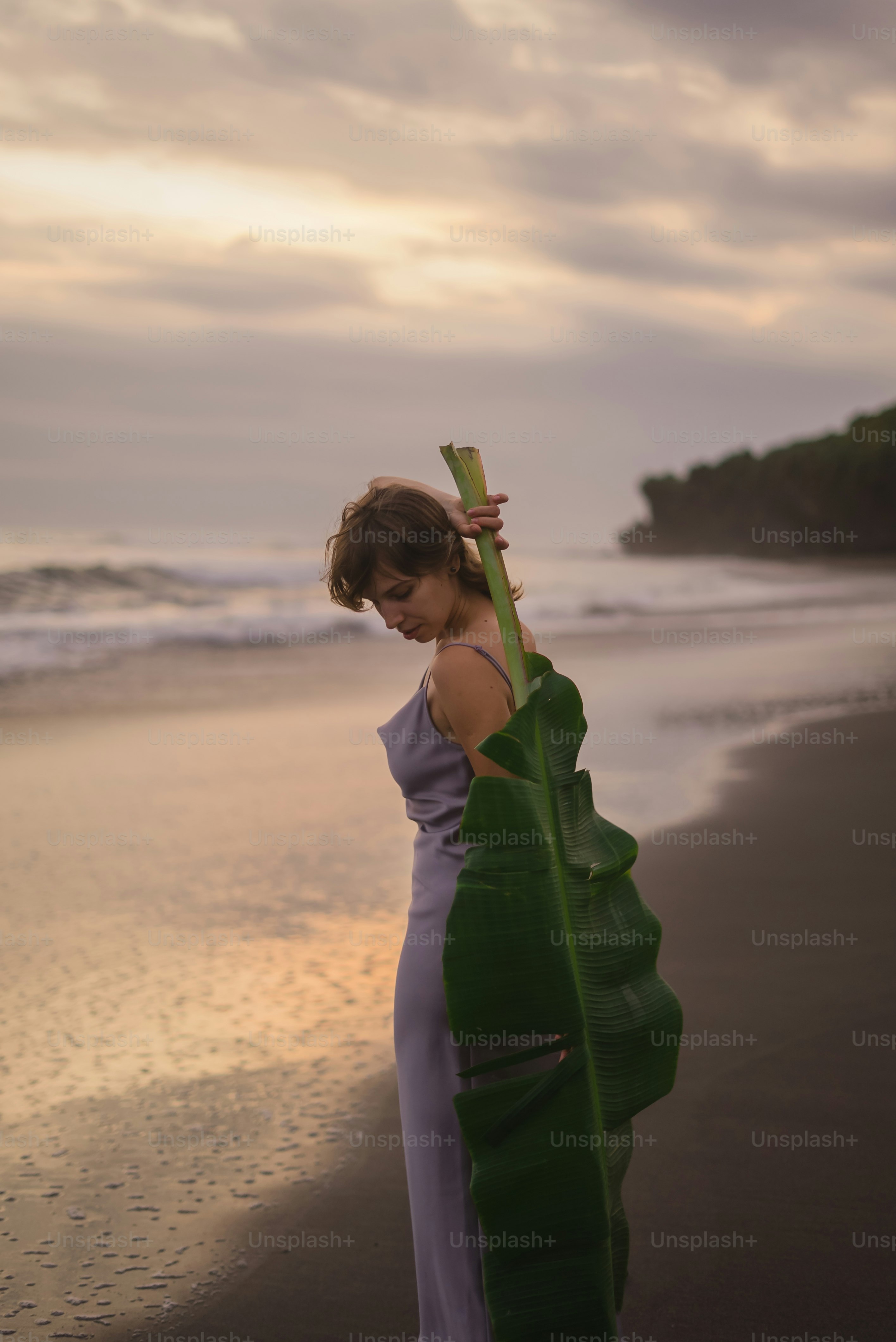 Una mujer parada en una playa junto al océano