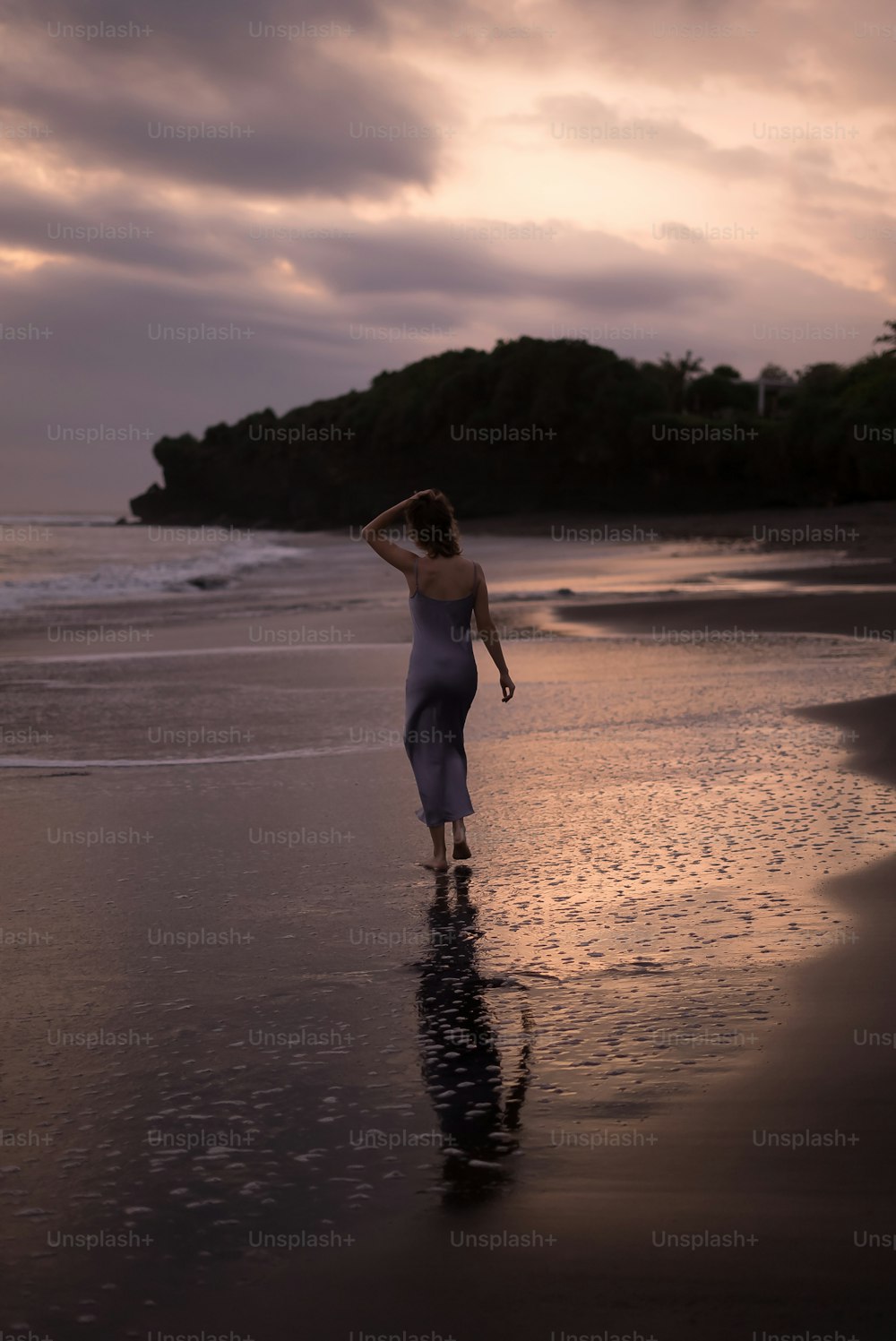 Una mujer parada en una playa junto al océano
