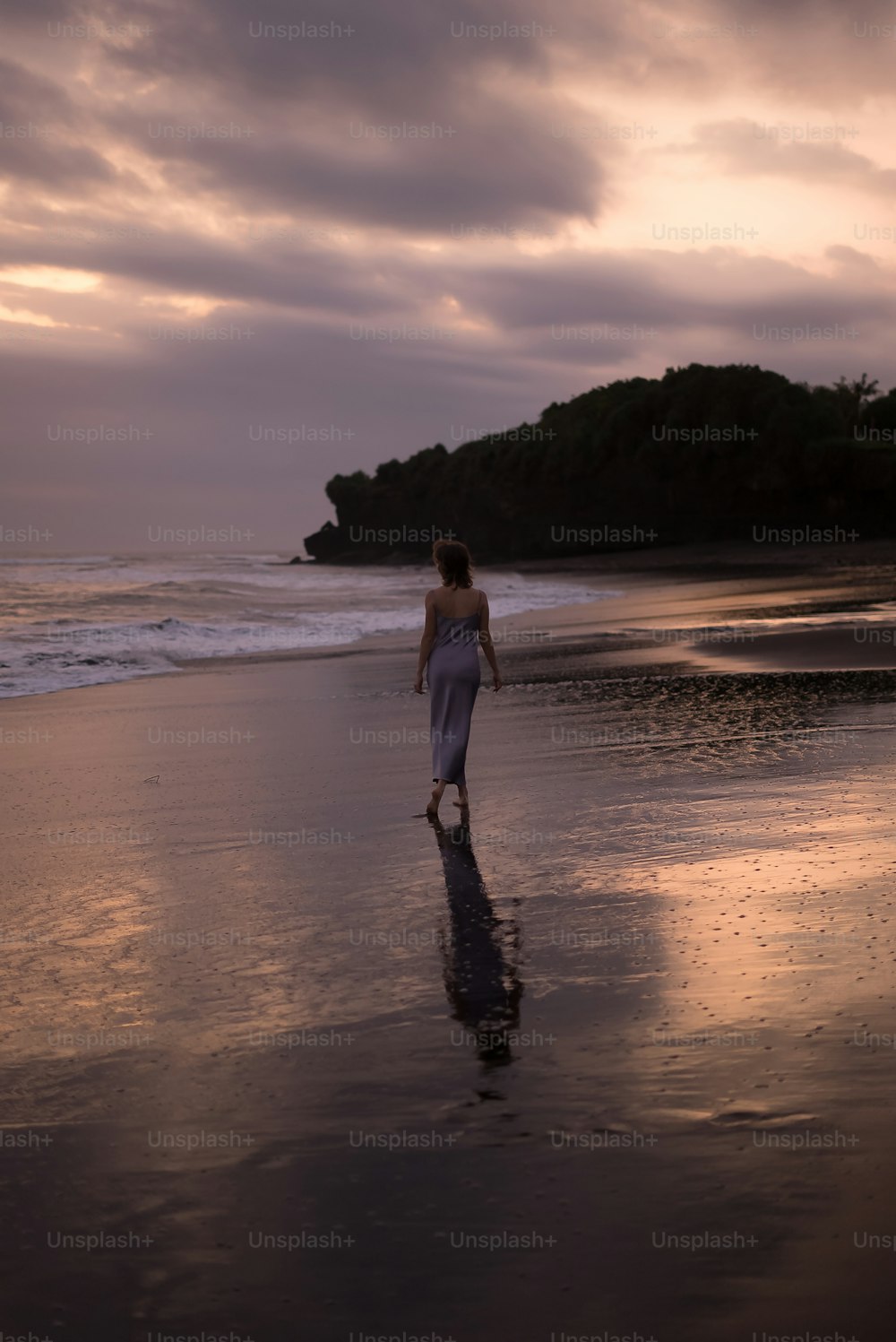 Una donna che cammina lungo una spiaggia vicino all'oceano